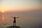 Male runner overlooking ocean sunset