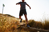 Male runner descending trail hillside