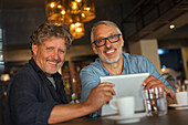 Portrait smiling men using digital tablet
