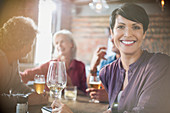 Woman drinking white wine dining with friends