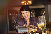 Portrait smiling woman giving gift in bar