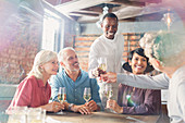 Waiter serving white wine to couples