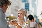 Senior couple holding hands drinking white wine