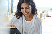 Smiling woman in bathrobe using digital tablet