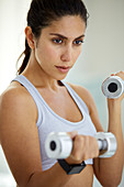 Woman doing biceps curls with dumbbells