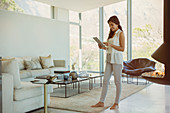 Woman using digital tablet in luxury living room