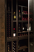Wine bottles organized on wooden shelves