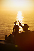 Silhouette couple toasting wine glasses