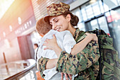 Son greeting and hugging soldier mom at airport