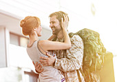 Wife greeting and hugging soldier husband