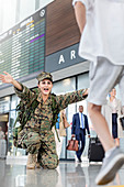Son running greeting mother soldier at airport
