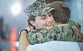 Husband greeting hugging soldier wife