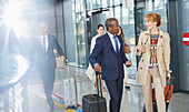 Business people talking and walking with suitcases