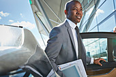 Businessman arriving at airport getting out of car