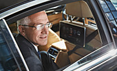 Businessman looking out town car window