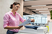 Businesswoman using photocopier in office