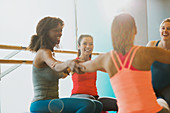 Smiling women joining arms in circle