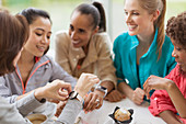 Smiling women friends looking at smart watches