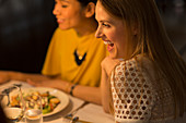 Smiling woman dining with friends