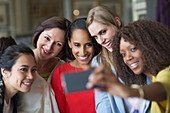 Women friends taking selfie with camera phone