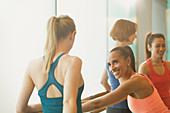Women talking and stretching at barre