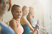 Portrait smiling women stretching legs at barre