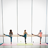 Women stretching legs at barre