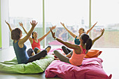 Women leaning with arms raised on cushions