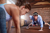 Young man with headphones doing one-arm push-ups