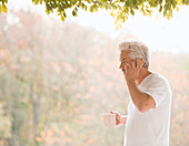 Man talking on cell phone and drinking coffee