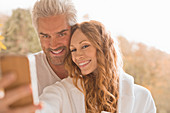 Affectionate couple smiling taking selfie outdoors