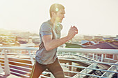 Determined male runner running at sunrise
