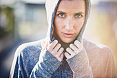 Portrait serious female runner wearing hoody