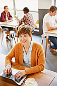 Businesswoman drinking coffee working at laptop