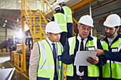 Manager and workers with clipboard meeting