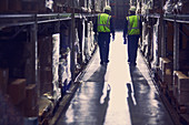 Workers walking in aisle of distribution warehouse