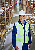 Portrait smiling worker with clipboard aisle