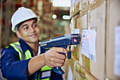 Worker with scanner scanning barcode on box