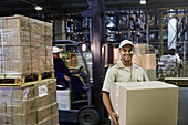 Portrait smiling worker carrying cardboard box