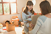Young women moving packing boxes