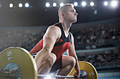 Focused male weightlifter lifting barbell