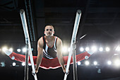 Male gymnast performing splits on parallel bars