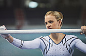 Female gymnast chalking uneven bars