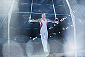 Male gymnast performing on gymnastics rings