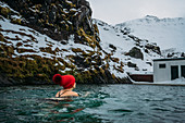 Woman in stocking cap swimming, Iceland