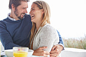 Happy couple hugging and laughing on patio