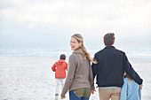 Portrait happy family walking on winter beach