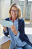 Portrait smiling senior woman using digital tablet