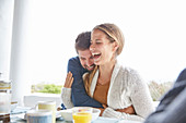 Couple hugging and laughing at breakfast