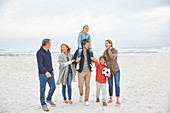 Multi-generation family walking on winter beach